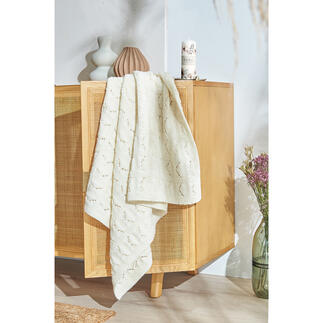 Decke aus Nuovo Merino 120, drapiert über einen Holzmöbel, mit filigranem Muster.