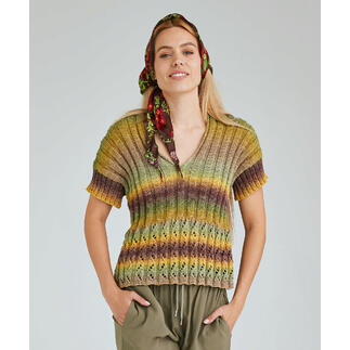Frau lächelt in einem bunter gestrickten Pulli mit V-Ausschnitt und zeigt einen entspannten Look.
