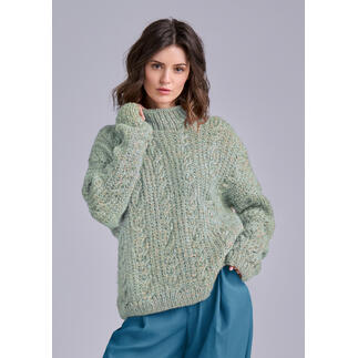 Frau in einem grünen, strukturierten Pullover, schaut wahrhaftig in die Kamera.