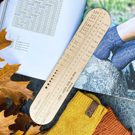 Sockenlineal für 4-fach Garne auf einem Tisch mit Laub.