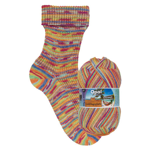 Bunte Socke mit gelb-orange Streifen aus Sockenwolle Lieblingsplatz von Opal, neben einem Knäuel der gleichen Wolle.