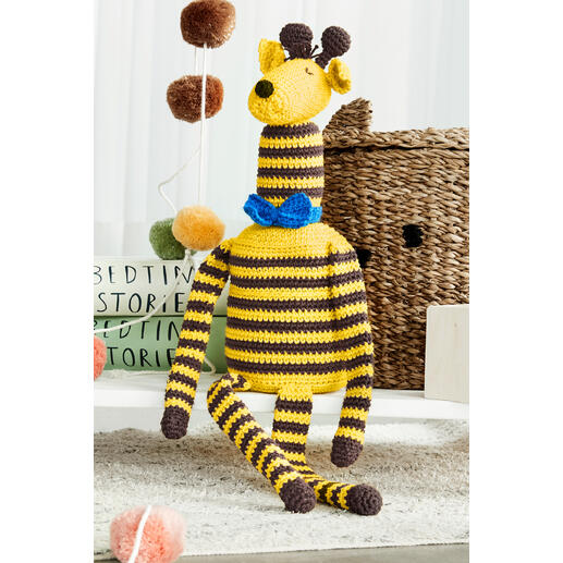 Häkelgiraffe ‚Gordon‘ aus Cotonara und Poco, sitzend mit blauer Schleife.