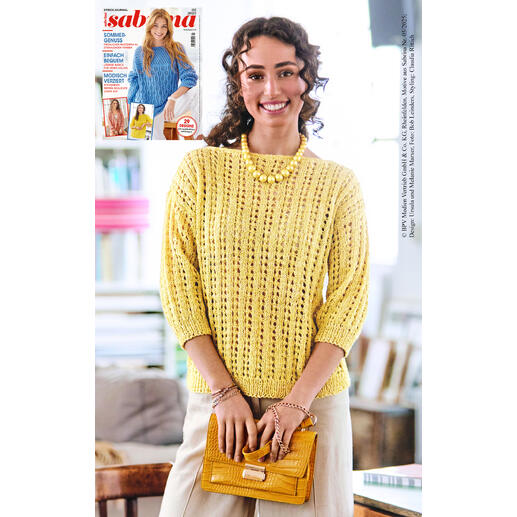 Frau in gelbem Pullover aus Contrato lächelt mit einer Handtasche.