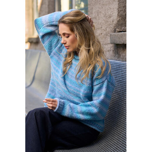Gemusterter Pullover aus Luma, getragen von einer Frau in einem modernen Setting.