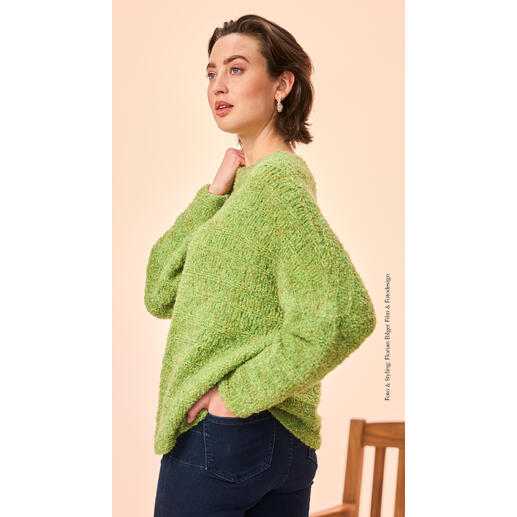 Pullover aus Boucle in leuchtendem Grün, getragen von einer nachdenklichen Frau.