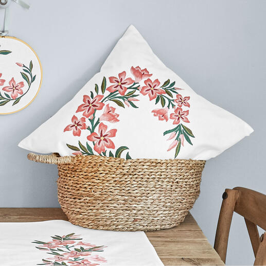 Kissen mit Oleanderstickerei in einem Korb auf einem Tisch