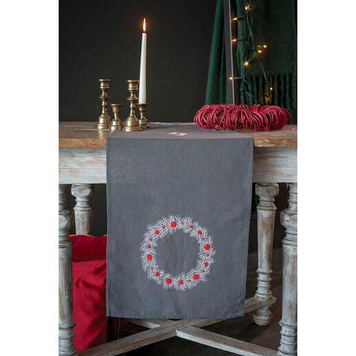 Tischläufer mit modernem Kranzdesign auf einem Holztisch, dekoriert mit Kerzen.