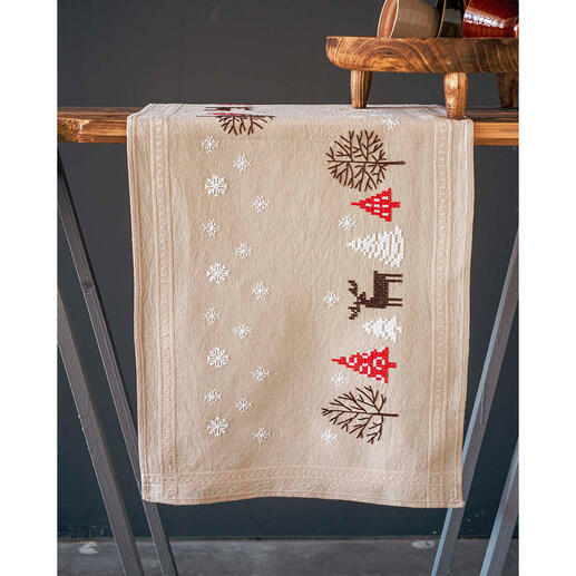 Tischläufer mit weihnachtlichen Motiven wie Bäumen und Rentieren, aufgehangt.