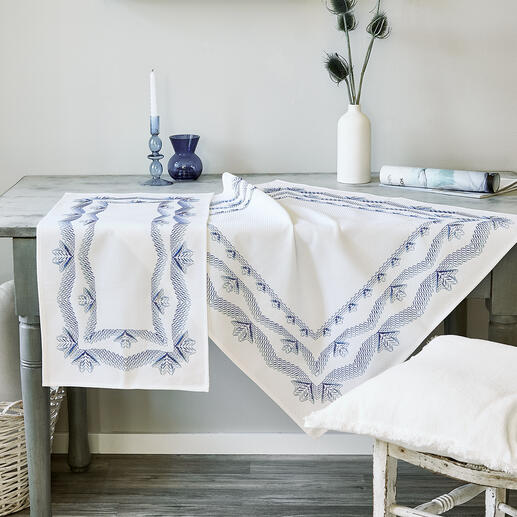 Tischwäsche mit blauem Gerstenkornmuster auf einem Holztisch.