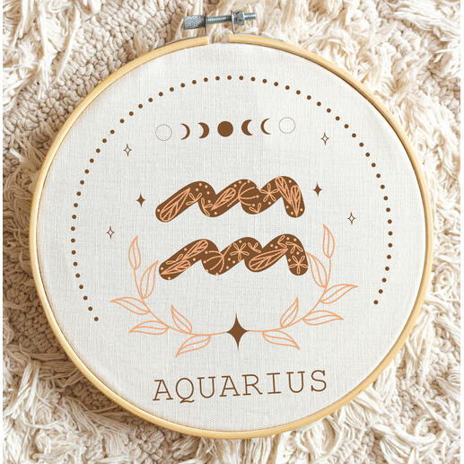 Minimalistische Stickerei des Sternzeichens Wassermann mit grafischen Elementen.