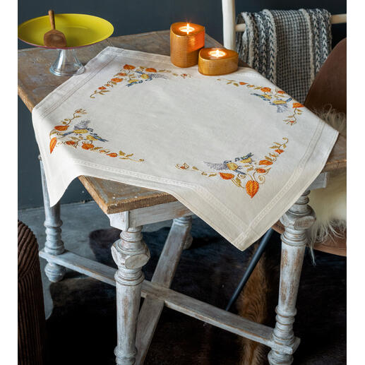 Tischwäsche mit Meisen und Lampionblumen auf einem Tisch.