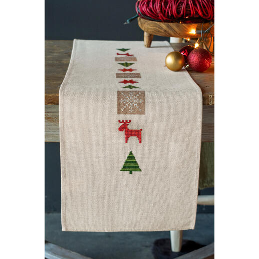 Tischläufer mit weihnachtlichen Symbolen wie Rentieren und Sternen.