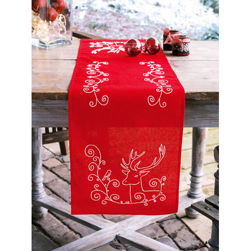 Tischläufer in Rot mit einem Elch und einem Vogel, dekoriert mit Weihnachtskugeln.