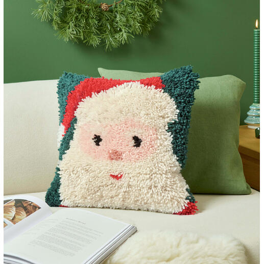 Santa-Kissen auf einer Couch mit grünen und beige Kissen.