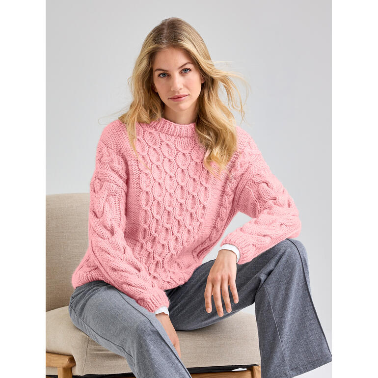 Frau in rosa Pullover aus Canoso, sitzt lässig auf einem Stuhl