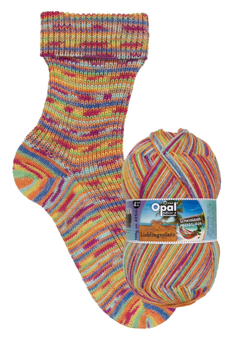 Bunte Socke mit gelb-orange Streifen aus Sockenwolle Lieblingsplatz von Opal, neben einem Knäuel der gleichen Wolle.
