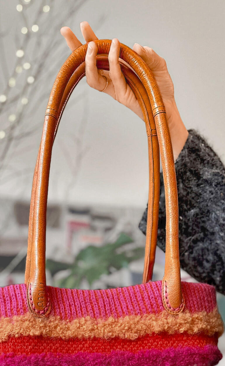 Taschengriff Bibi in Whisky-Farbe, gehalten von einer Hand, zeigt das Material und die Details.