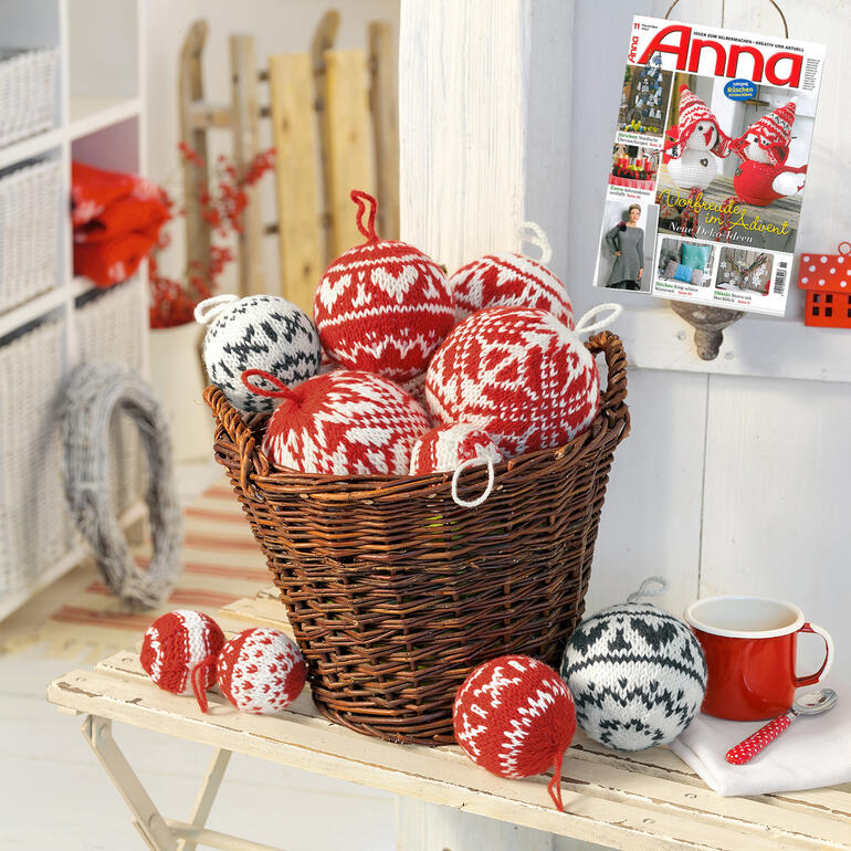Korb voller bunter handgestrickter Weihnachtskugeln