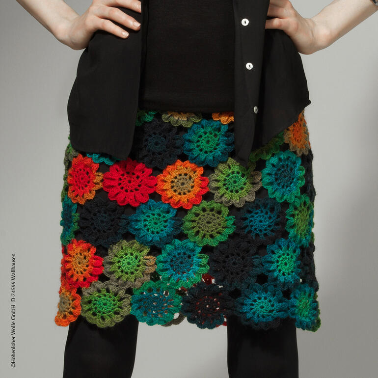 Rock aus buntem gehäkeltem Zauberball von Schoppel Wolle vor einem neutralen Hintergrund.