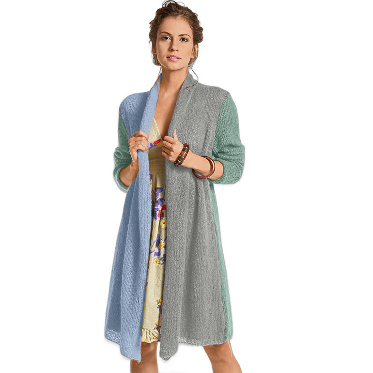 Frau trägt einen hellen Mantel über einem bunten Kleid, steht auf einem neutralen Hintergrund.