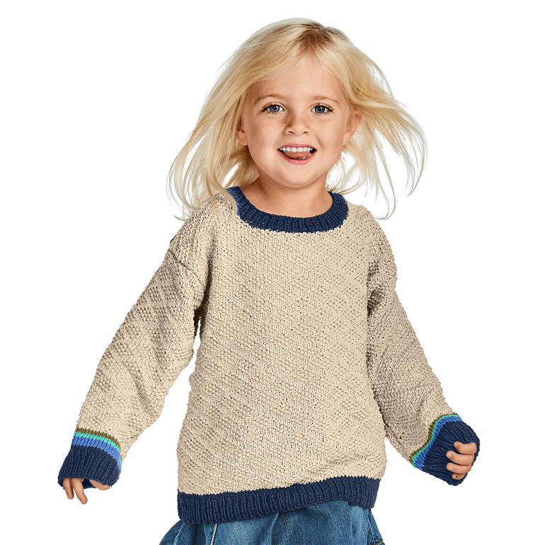 Lächelndes Kind in naturally beigem Pullover aus Cottonprima mit blauen Ärmeln.