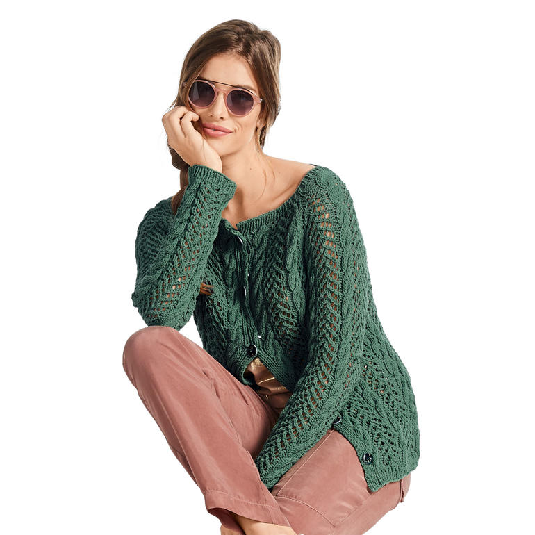Frau in grüner Strickjacke mit Lochmuster, trägt Sonnenbrille.