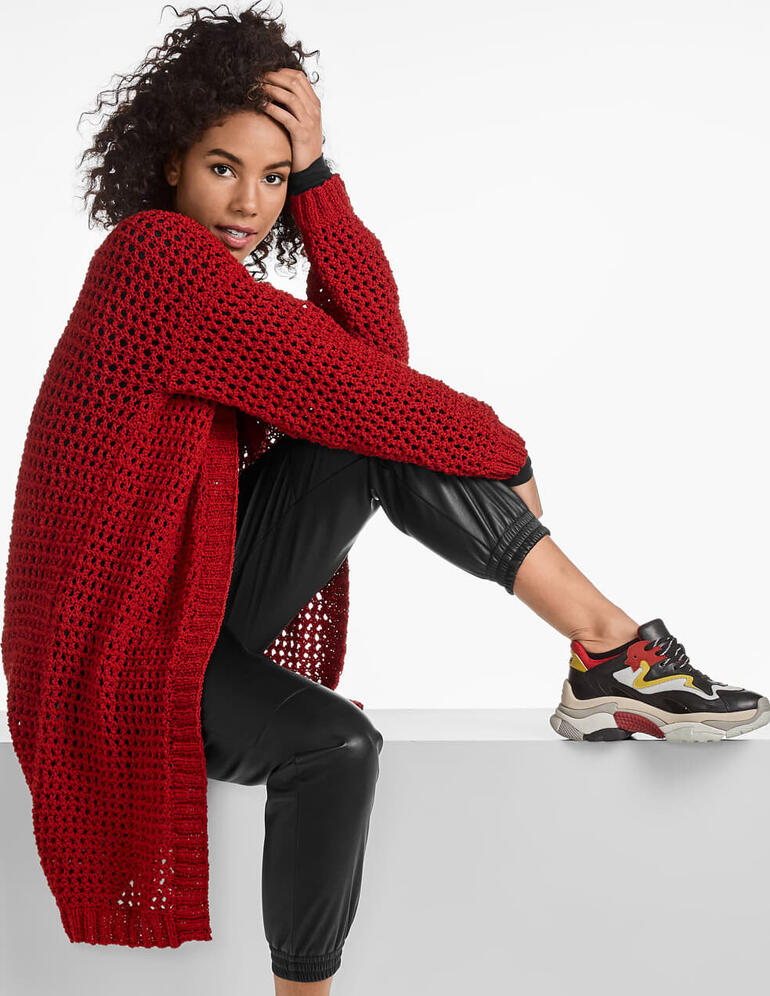 Langer roter Mantel aus Onda, getragen von einer Frau mit lockigem Haar.