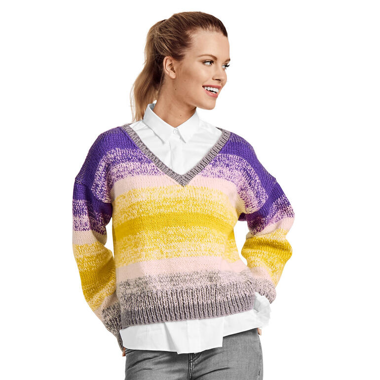 Bunter Damenpullover im Streifen-Muster, lässige Pose mit offener Bluse.
