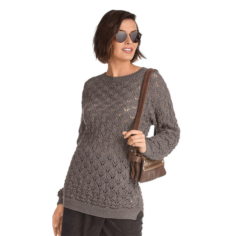 Frau trägt einen grauen Pullover mit Lochmuster und lässigem Stil.