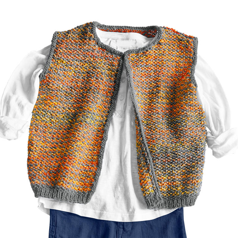 Bunte Kinderweste aus Monello-175, auf einem weißen Oberteil drapiert.