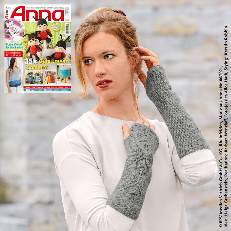 Dame trägt graue Armstulpen aus Rima, schaut nachdenklich.