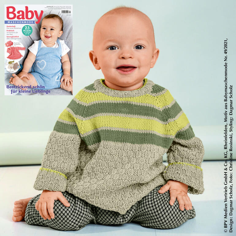 Baby trägt einen gestreiften Pulli aus Cotone-Emozione, sitzt lächelnd.