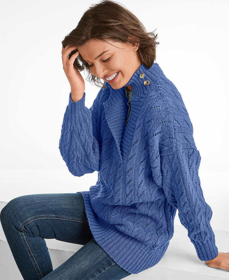 Pullover aus hellblauem Nuovo Merino 180 mit Kragenknöpfen, getragen von einer lachenden Frau.