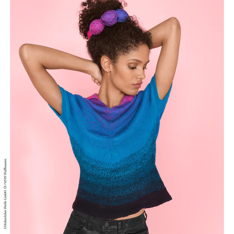 Frau in buntem Top aus Zauberperlen mit chicer Frisur vor pinkem Hintergrund.