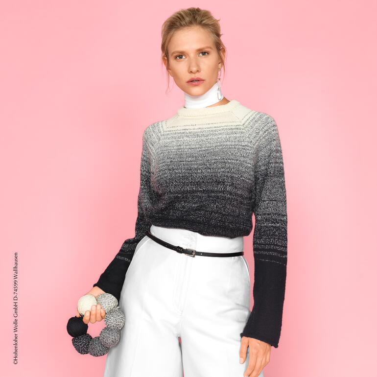 Frau in schickem, grau-black gradient Pullover in elegantem Look vor pinkem Hintergrund.