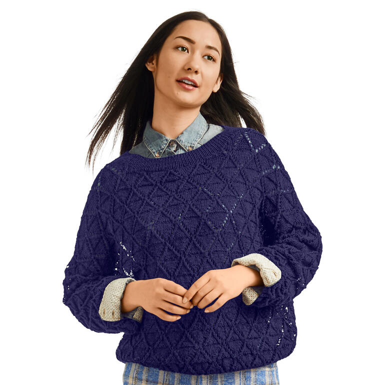 Frau in dunkelblauem Pullover aus Seidana® mit einem strukturierten Muster, lächelt.