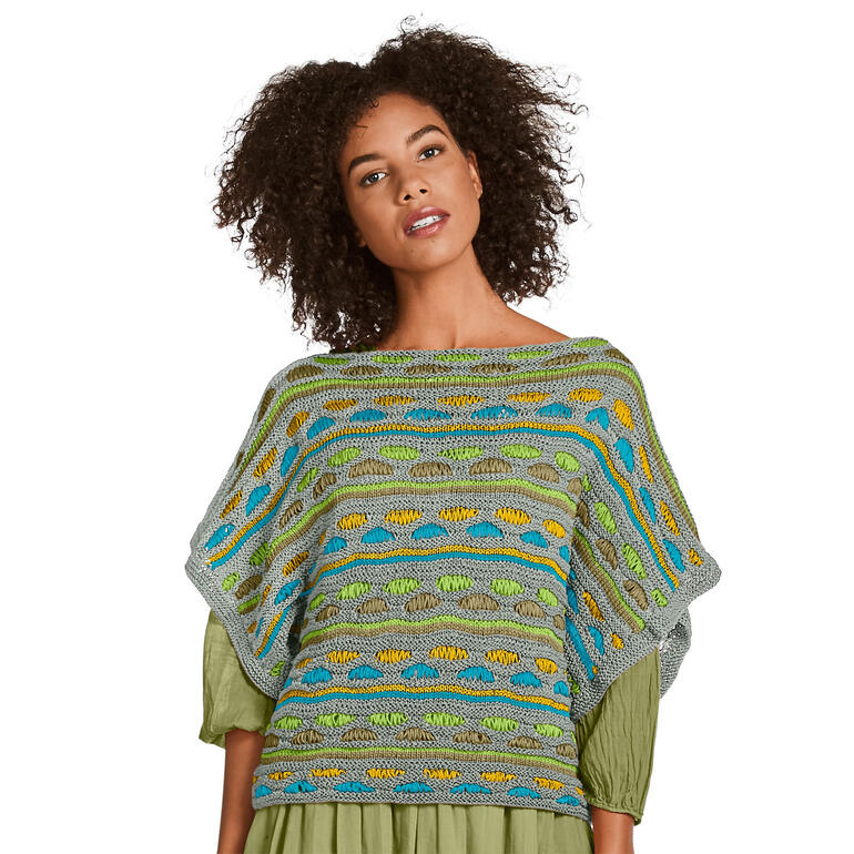 Frau in bunt gestreiftem Pullover aus Cottonprima, mit weiten Ärmeln.