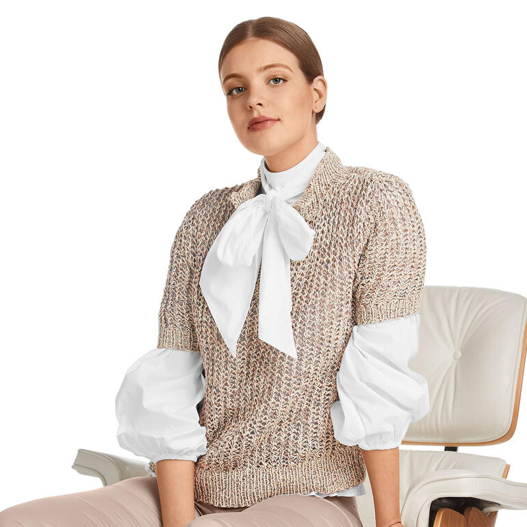 Frau in Polo-Pulli aus Oletta mit weitem Kragen, sitzend.