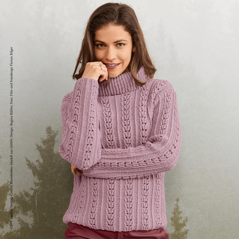 Frau in lila Pullover mit Rollkragen vor neutralem Hintergrund.