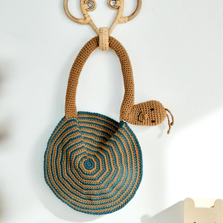 Häkel-Schnecken-Schlabberlatz in Braun und Blau mit Gesicht.