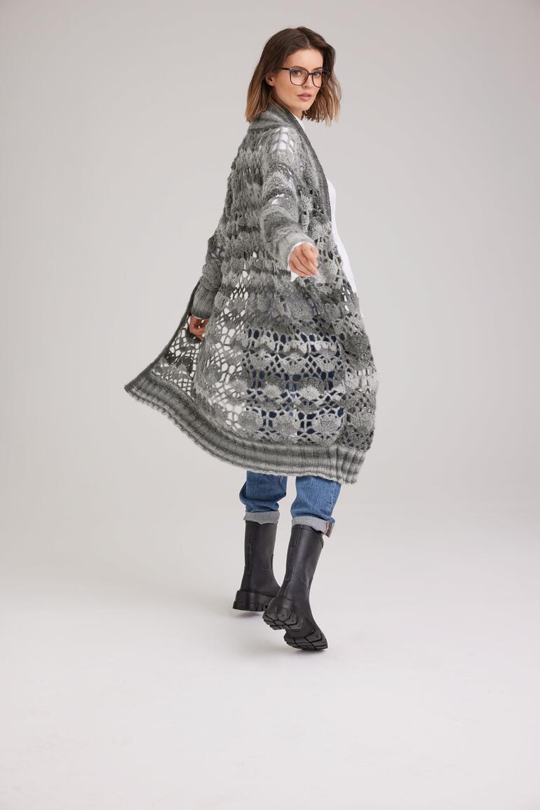 Frau in längerer Jacke aus Scala in attraktivem Design läuft in einem modischen Style.