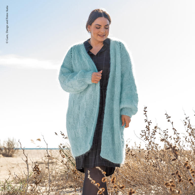 Lang geschnittene Jacke aus Ingenua, leicht offen getragen, in sanften Farben.