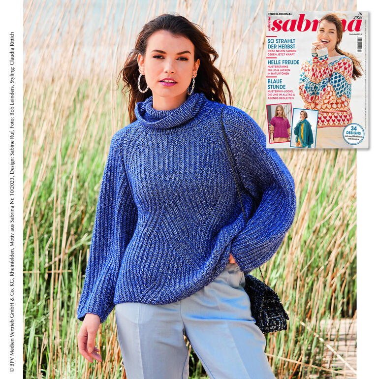 Frau trägt einen modischen Raglanpullover aus Wool-Cotton, steht am Strand.