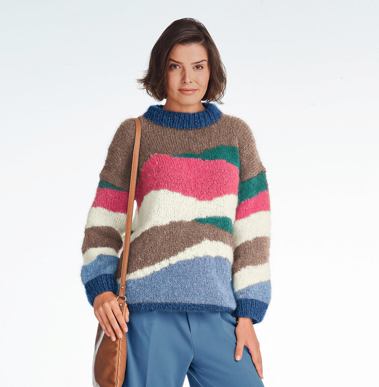 Bunter Pullover mit abstrahierter Farbblockierung auf hellem Hintergrund.