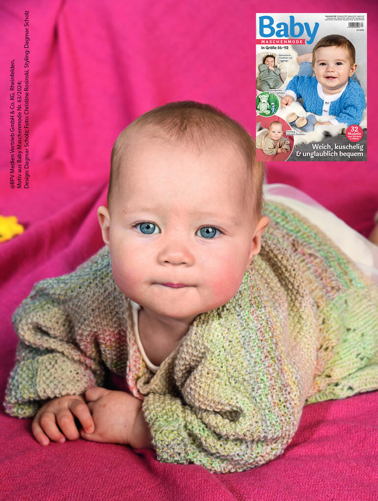 Baby krabbelt auf einer Unterlage, trägt eine bunte Jacke, Mütze und Söckchen aus Monello-175 Color.