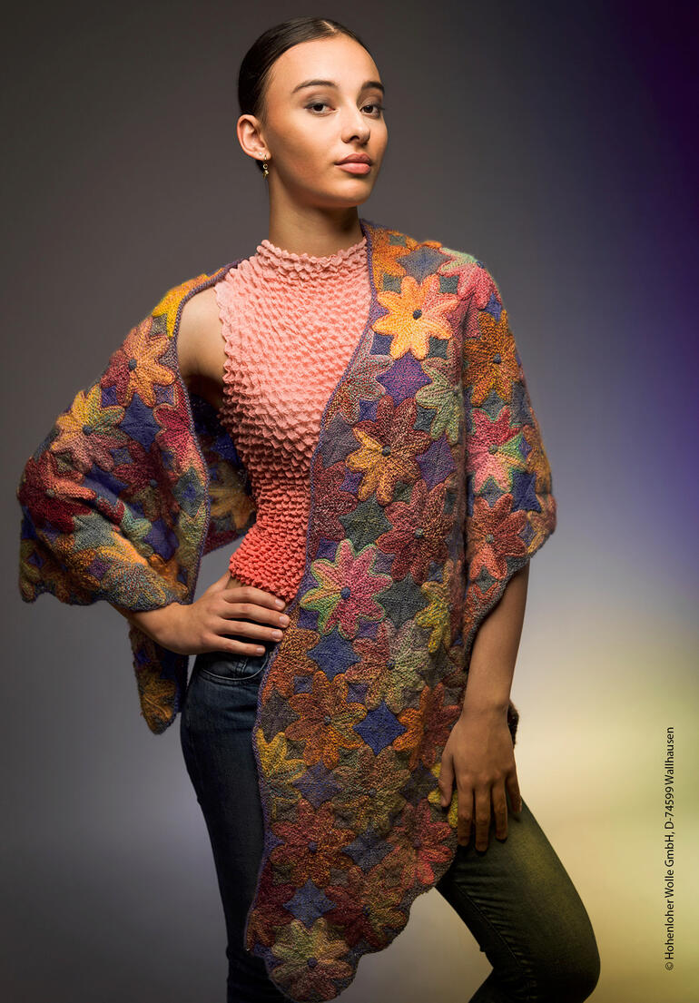 Frau trägt einen bunten, gehäkelten Schal über den Schultern.