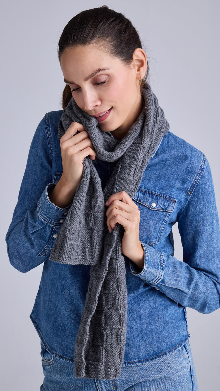 Schal aus Wool-Cashmere, grau, um den Hals einer Frau gewickelt, lächelt