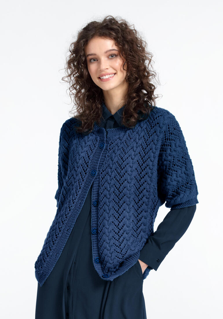 Frau trägt eine dunkelblaue Jacke aus Babyboomer von Junghans-Wolle.