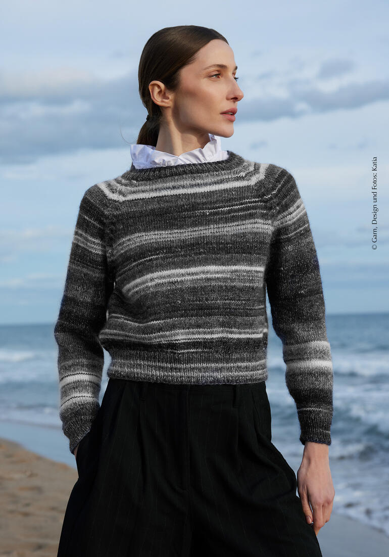 Pullover aus Merino Seta Tones, getragen von einer Frau am Strand.