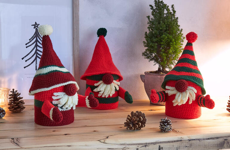 Drei Wichtel Weihnachtsdosen, farbenfrohes Design aus Poco, auf einem Tisch.